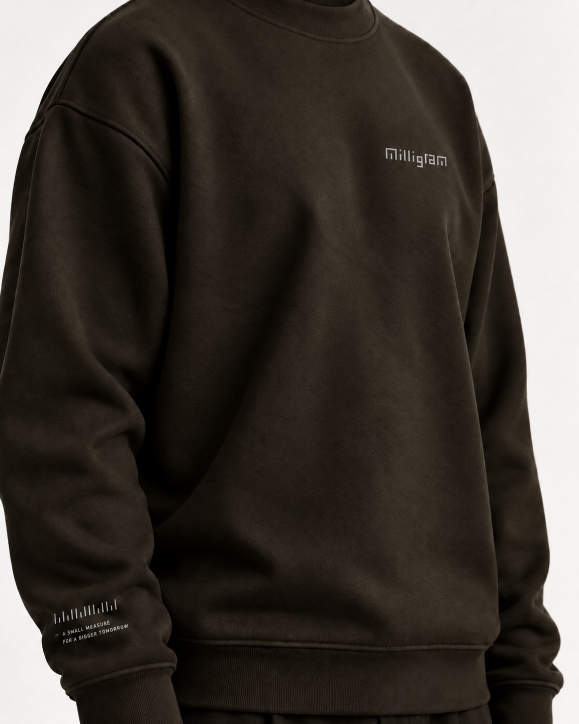 a dark sweatshirt with the wordmark at the chest and the ruler strip on the cuff