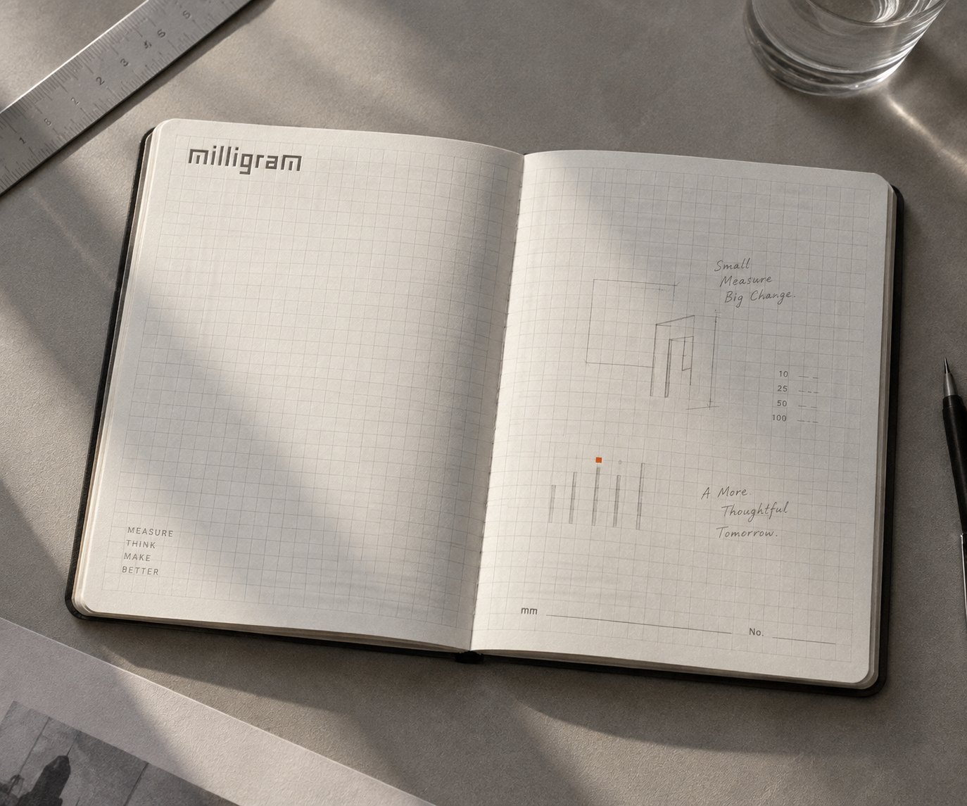 an open notebook on grid paper, the wordmark and a pencil study of the symbol